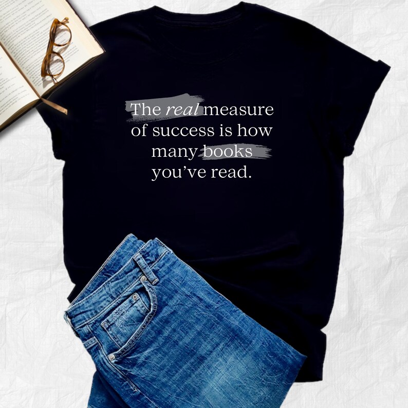 May include: Black t-shirt with the text "The real measure of success is how many books you've read." printed in white with gray lines underneath.