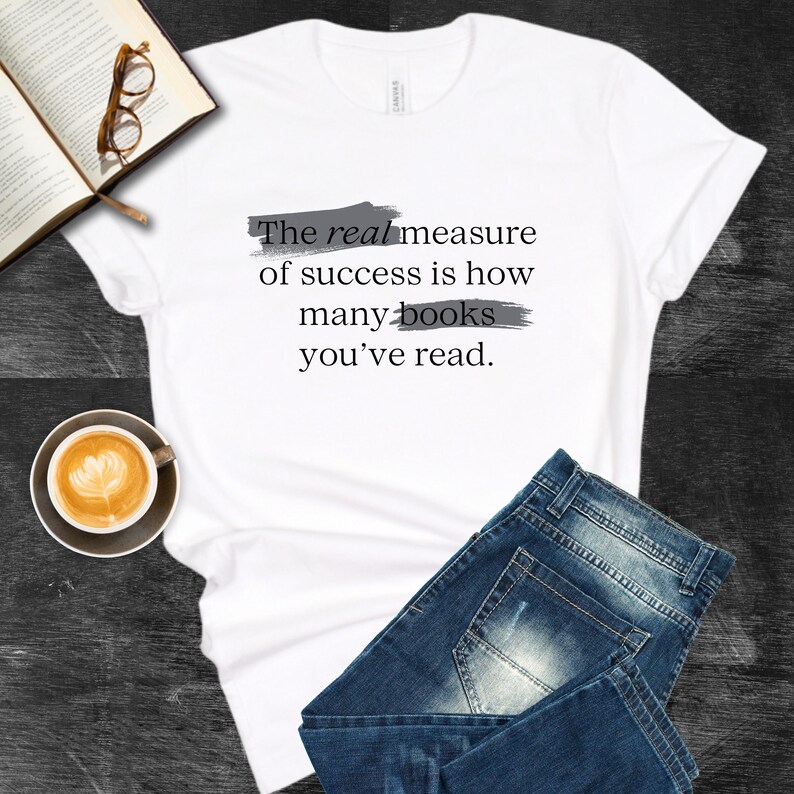 May include: White t-shirt with the text "The real measure of success is how many books you've read." printed in black with gray brushstrokes underneath each line.