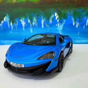 May include: A blue toy car with a black license plate that says "JOSIE".