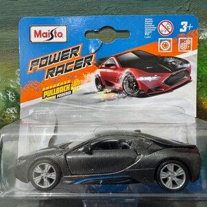 May include: A Maisto Power Racer toy car in a clear plastic package. The die-cast model is dark gray with blue accents. The packaging features a red sports car graphic and the text "POWER RACER".
