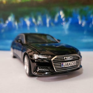 May include: Black Audi A6 saloon toy car with a personalised number plate that reads "JAKOB".