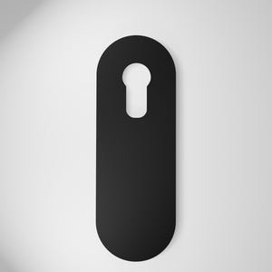 以下が含まれることがあります： 上部に鍵穴の切り抜きがある黒いドアハンガー。ドアハンガーは、丸みを帯びたエッジを持つ長い楕円形です。背景は白から明るいグレーへのグラデーションです。