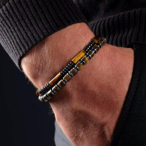 May include: A layered bracelet with brown tiger's eye and black hematite beads.