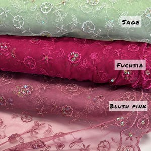 Peut inclure: Gros plan sur trois rouleaux de tissu brod&eacute; vert sauge, fuchsia et rose blush. Le tissu est orn&eacute; de motifs floraux et de feuilles et agr&eacute;ment&eacute; de paillettes. Le texte "LIMITED STOCK Will Not Be Restocked" est en bas.