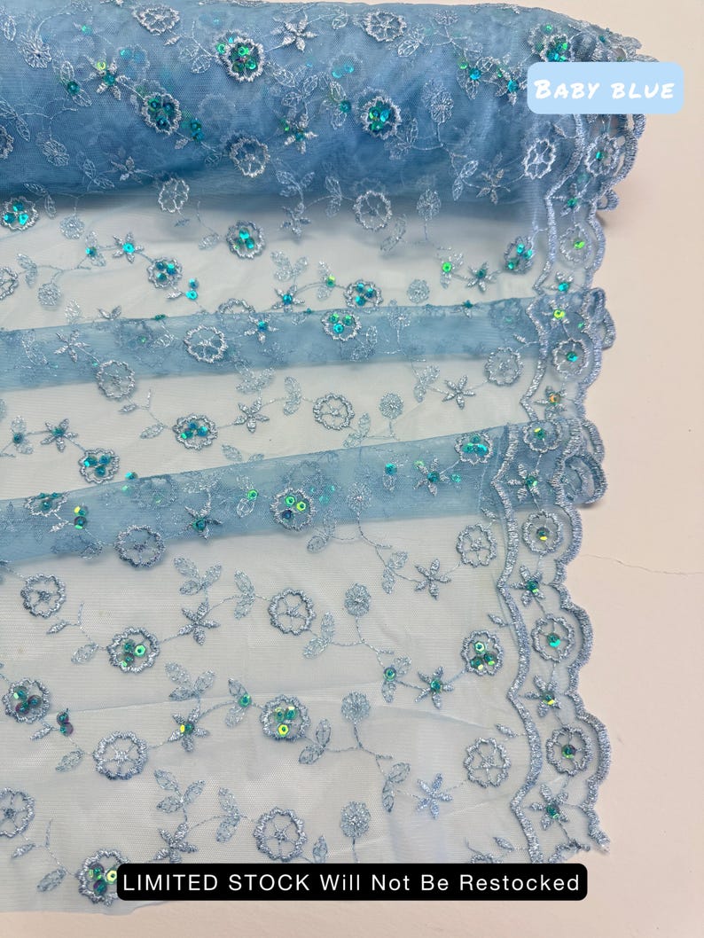 Peut inclure: Tissu brod&eacute; bleu clair avec des d&eacute;tails floraux et des paillettes. Le tissu a un bord festonn&eacute; et le texte "BABY BLUE" est visible. Le texte "LIMITED STOCK Will Not Be Restocked" est &eacute;galement visible.
