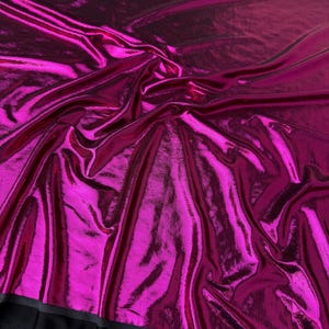 May include: A vibrant magenta fabric with a high-gloss, metallic finish and a crinkled texture. The material is draped in soft folds, creating light and shadow across the surface. Text on the image reads Wide 58/60 inches and Magenta.