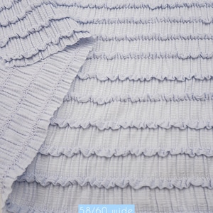 Powder blue smocked stretch fabric. Crinkle bubble knit material for baby headbands, swimwear coverups, and summer apparel.