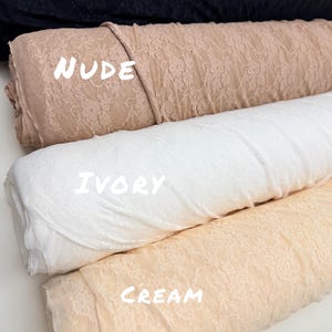May include: Close-up of four rolls of lace fabric in various colors. The colors include black, nude, ivory, and cream. The word "BLACK" is written in white across the top roll. The word "NUDE" is written in white across the second roll. The word "IVORY" is written in white across the third roll. The word "CREAM" is written in white across the bottom roll.