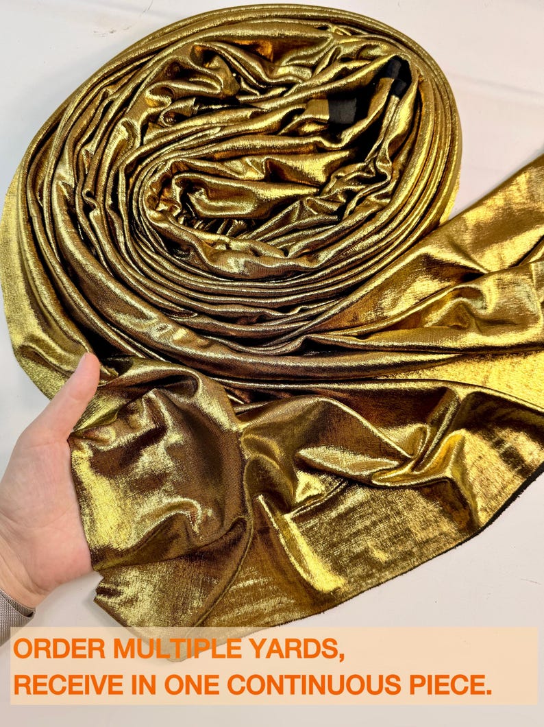 May include: A roll of metallic gold fabric with a shimmering, reflective surface and a soft, draped texture. The fabric is coiled into a circular shape, showcasing its bright, lustrous finish. Text at the bottom reads: ORDER MULTIPLE YARDS, RECEIVE IN ONE CONTINUOUS PIECE.