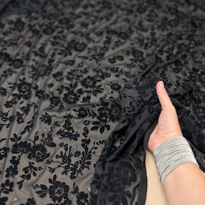 以下が含まれることがあります： 黒の透き通った生地に、ベルベットの花柄が施されています。生地は柔らかく繊細で、花柄は複雑でエレガントです。