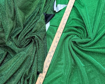 May include: Hunter Green sparkly fabric with a ruler showing it is 54/56 inches wide.