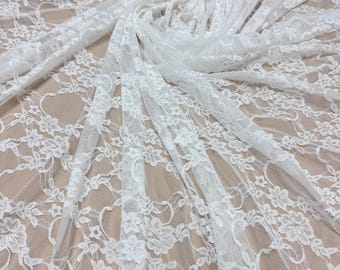 May include: White lace fabric with a floral pattern. The delicate lace is arranged in soft folds, creating a textured and layered effect. The fabric is suitable for various craft and design projects.