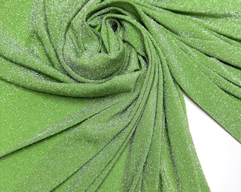 May include: A vibrant green fabric with a subtle shimmer, tightly swirled to showcase its texture. The fabric is labeled "Kiwi" and "4 way stretch", suggesting its flexibility and use in clothing or crafts.