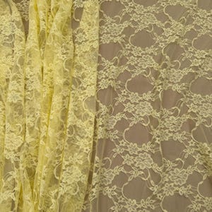 K&ouml;nnte beinhalten: Nahaufnahme eines hellgelben Spitzenstoffs. Das zarte Blumenmuster ist im gesamten Material sichtbar. Der Stoff ist drapiert und zeigt die Textur und Transparenz der Spitze. Ideal f&uuml;r Bekleidung, Basteln und Heimdekoration.