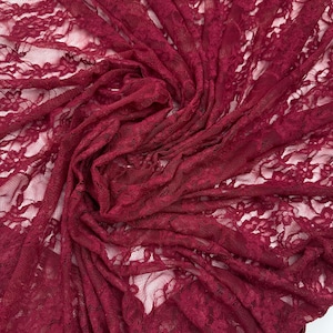 K&ouml;nnte beinhalten: Nahaufnahme eines tiefroten Spitzenstoffs. Das zarte Blumenmuster ist im gesamten Textil sichtbar. Der Stoff ist gerafft und drapiert, wodurch Schatten entstehen und die komplizierten Details der Spitze hervorgehoben werden. Ideal f&uuml;r Kleidung und Bastelprojekte.