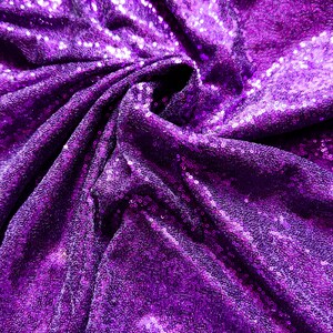 May include: Purple fabric with a sparkly, sequin texture. The fabric is draped and folded, creating a swirling pattern.