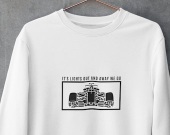 Peut inclure: Sweat-shirt blanc avec un graphique noir d'une voiture de course et le texte "It's lights out and away we go."
