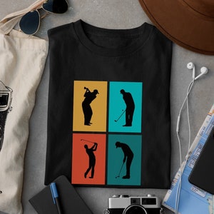 Könnte beinhalten: Schwarzes T-Shirt mit einer Retro-Grafik von vier Golfern in verschiedenen Posen. Die Golfer sind in Schwarz vor einem Hintergrund aus vier Quadraten in Gelb, Türkis, Orange und Türkisblau silhouettiert.