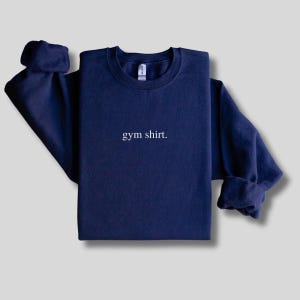 simple navy gym sweatshirt featuring a minimalist text design. Made with the Gildan 18000 sweatshirt