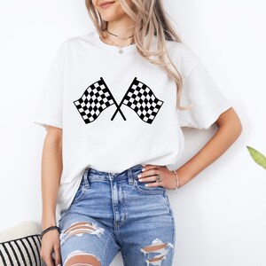 Puede incluir: Camiseta blanca con un gr&aacute;fico de bandera de carreras a cuadros en blanco y negro.
