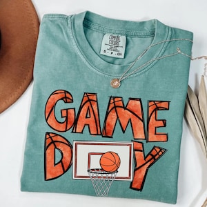 cute basketball shirt featuring a game day graphic made with basketball doodle font for a one of a kind piece