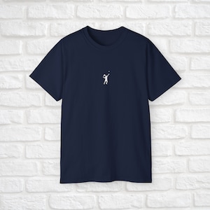 Pu&ograve; includere: Una t-shirt blu navy con una silhouette bianca di una persona che gioca a tennis.