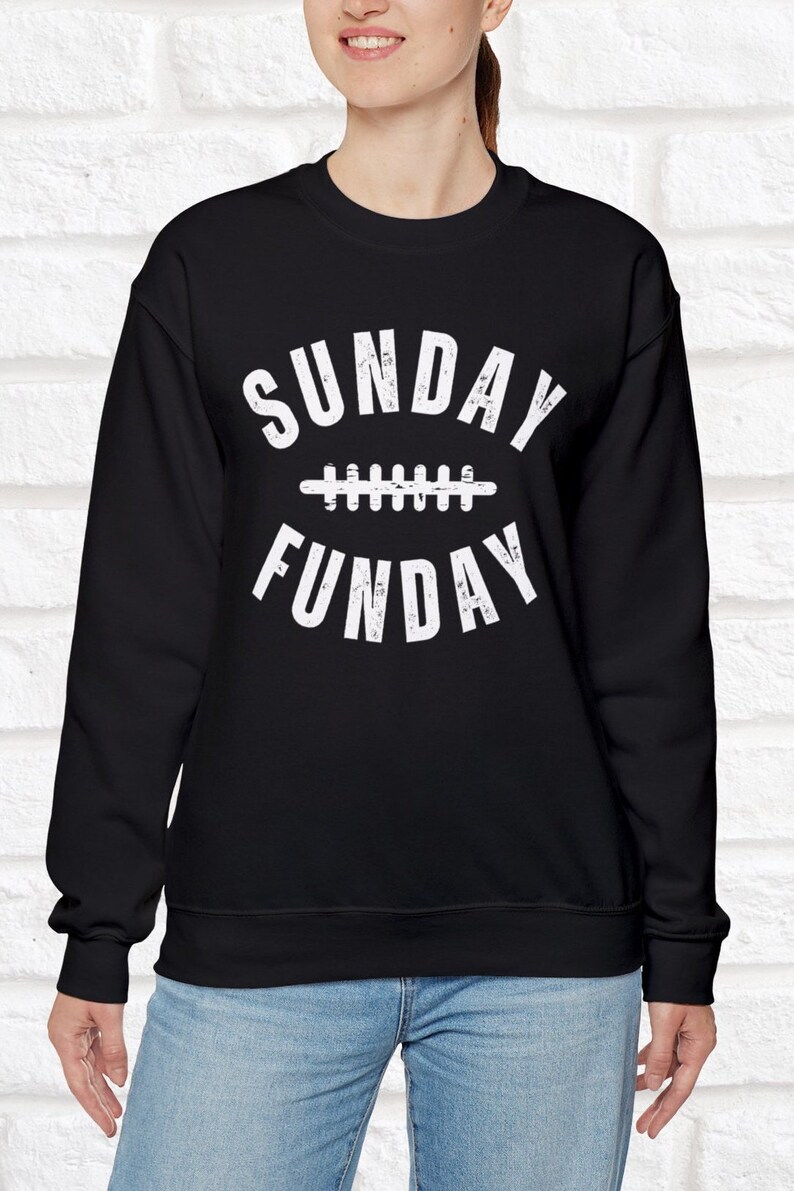 Op de afbeelding: Zwart sweatshirt met witte tekst die "SUNDAY FUNDAY" luidt met een voetbalafbeelding tussen de woorden.