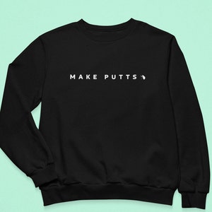 May include: Black sweatshirt with the text "MAKE PUTTS" in white.
