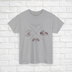 K&ouml;nnte beinhalten: Ein graues T-Shirt mit einem kastanienbraunen Design, das einen Cowboyhut, Stiefel, einen Longhorn-Stier, ein Rennwagen und karierte Flaggen zeigt.