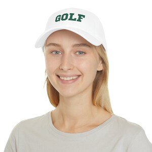 May include: A white baseball cap with a green embroidered "GOLF" logo.