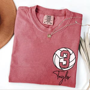 Crimson Comfort Colors 1717 t-shirt with a customizable name and number volleyball graphic.