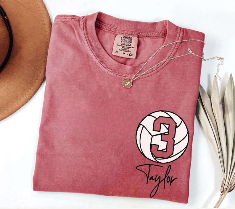 Crimson Comfort Colors 1717 t-shirt with a customizable name and number volleyball graphic.