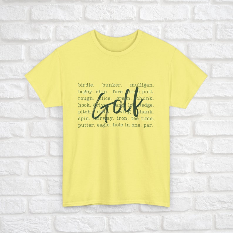 K&ouml;nnte beinhalten: Gelbes T-Shirt mit dem Wort "Golf" in Gr&uuml;n und umgeben von einer Liste von Golfbegriffen.