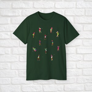 Może przedstawiać: Zielony t-shirt z nadrukiem kobiet grających w golfa w r&oacute;żnych pozach. Kobiety ubierają się w r&oacute;żne kolory, w tym r&oacute;żowy, zielony i ż&oacute;łty.