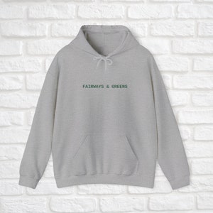 Puede incluir: Una sudadera con capucha gris con un logotipo bordado en verde que dice "Fairways & Greens".