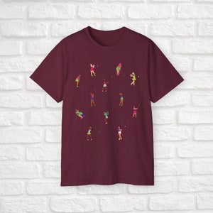 Może przedstawiać: Bordowy t-shirt z wzorem kobiet grających w golfa w r&oacute;żnych pozach. Kobiety są ubrane w r&oacute;żne kolory i trzymają kije golfowe.