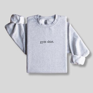 simple gray gym sweatshirt featuring a minimalist text design. Made with the Gildan 18000 sweatshirt