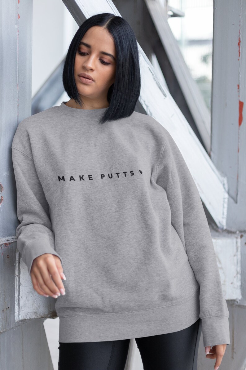 May include: A gray sweatshirt with the text "MAKE PUTTS" printed on the front.
