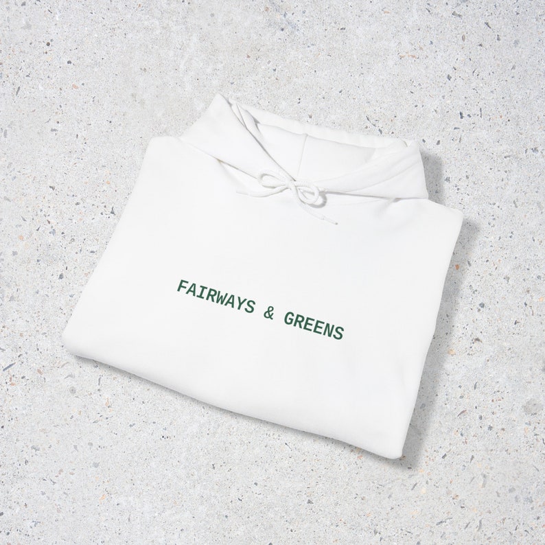 Puede incluir: Sudadera con capucha blanca con el texto "FAIRWAYS & GREENS" en letras verdes.