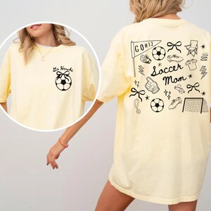 custom soccer t-shirt featuring a unique doodle graphic on the front and back. Customize the team name on the front and player number on the back to show your team pride. Crafted with the comfort colors 1717 tee