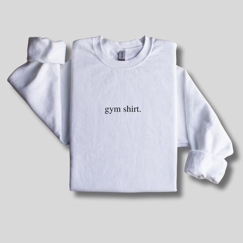 simple white gym sweatshirt featuring a minimalist text design. Made with the Gildan 18000 sweatshirt