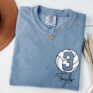 Blue jean Comfort Colors 1717 t-shirt with a customizable name and number volleyball graphic.
