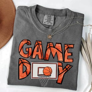 cute basketball shirt featuring a game day graphic made with basketball doodle font for a one of a kind piece