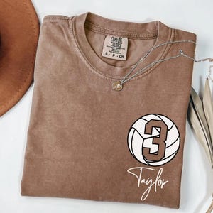 Espresso Comfort Colors 1717 t-shirt with a customizable name and number volleyball graphic.