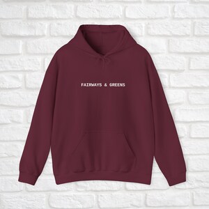 Puede incluir: Sudadera con capucha color burdeos con el texto "FAIRWAYS & GREENS" en blanco en la parte delantera.