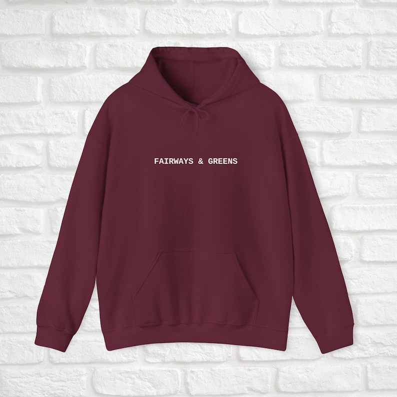 Puede incluir: Sudadera con capucha color burdeos con el texto "FAIRWAYS & GREENS" en blanco en la parte delantera.