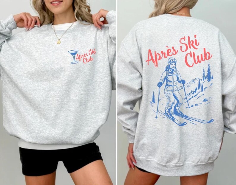 May include: Gray sweatshirt with a blue and red graphic of a skier on the back and the text "Apr&egrave;s Ski Club". The front of the sweatshirt has a blue and red graphic of a cocktail glass with the text "Apr&egrave;s Ski Club".