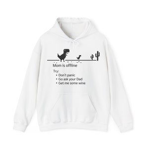 Puede incluir: Sudadera con capucha blanca con un gráfico negro del clásico juego de dinosaurio 'sin internet'. El texto dice 'Mamá está fuera de línea. Intenta: No te asustes. Ve a preguntarle a tu papá. Tráeme algo de vino.'