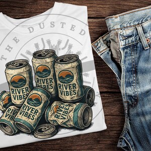 May include: A white t-shirt with a graphic of six cans of beer with the text "The Dusted River Vibes" printed on the front.