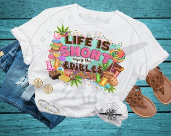 May include: White t-shirt with a graphic design of colorful candies, sprinkles, and the text "Life is Short, enjoy the Edibles".